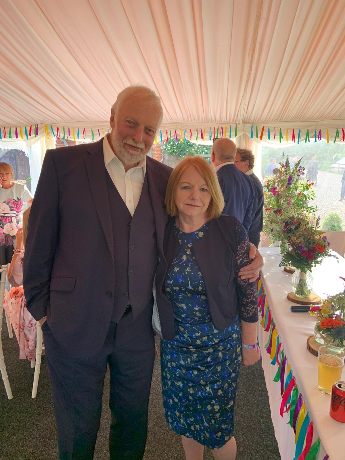 Dad dressed smartly beside a family member at a celebration