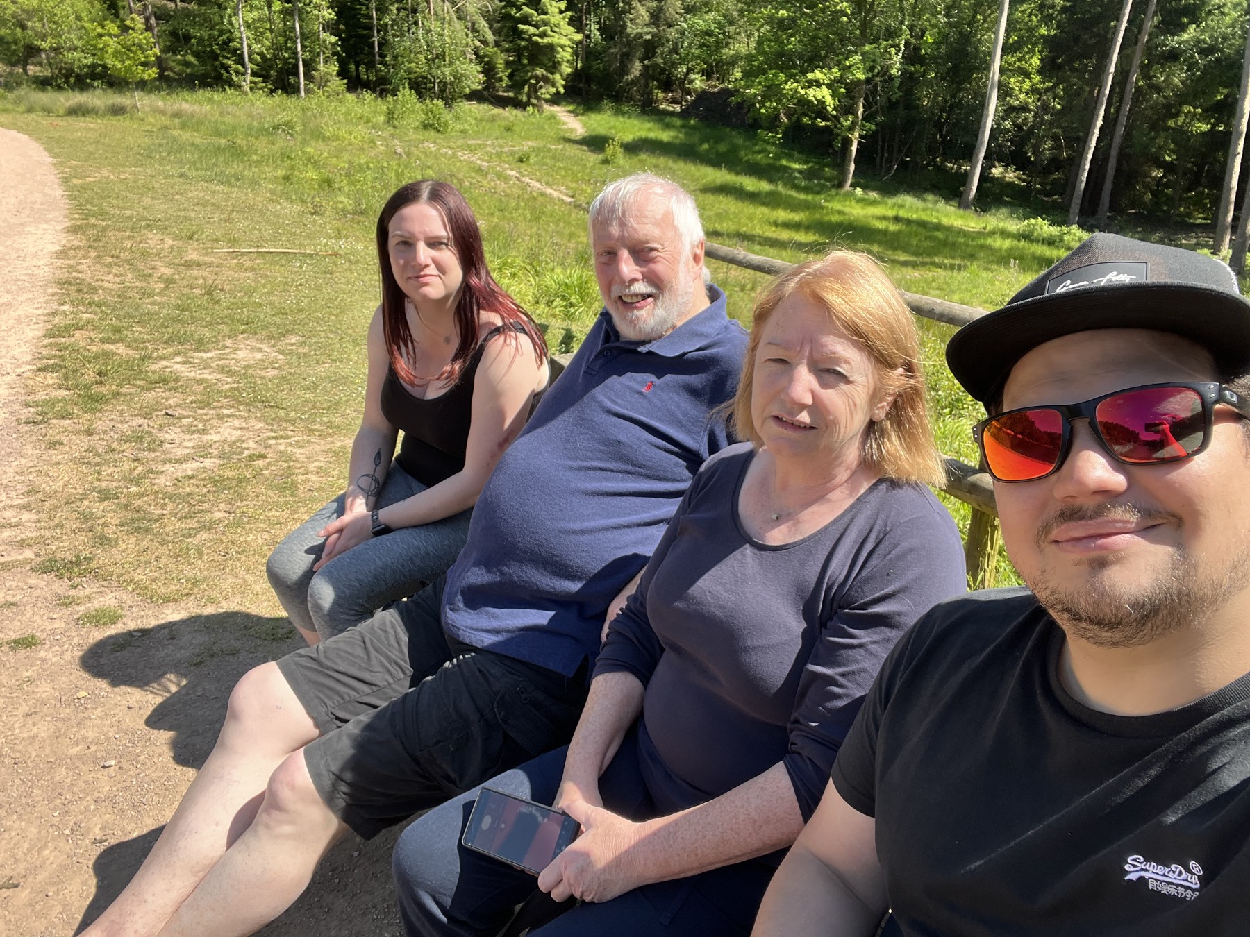 Family sitting together on a bench in the sunshine