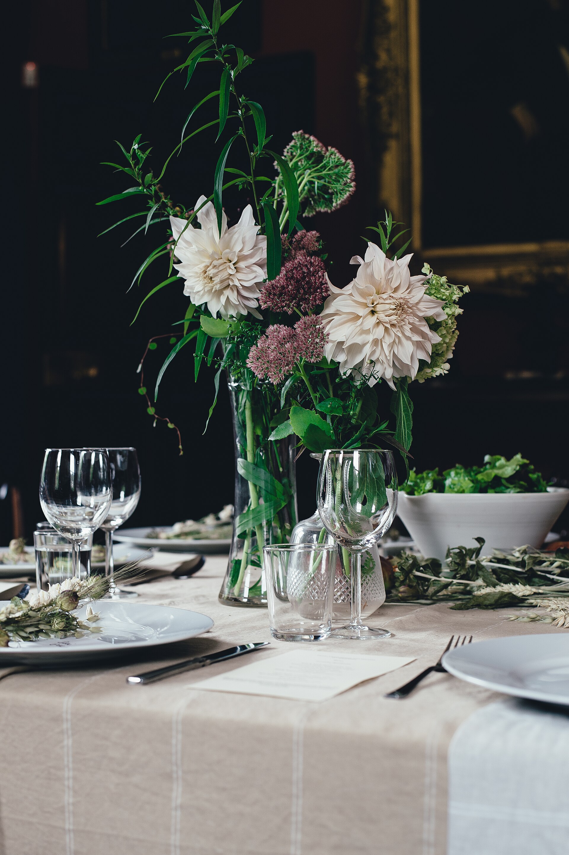An elegant dinner table set with flowers, plates, and wine glasses